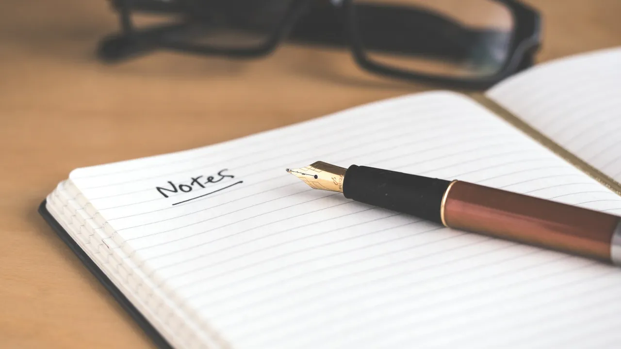 An open notebook with a pen, ready for writing notes
